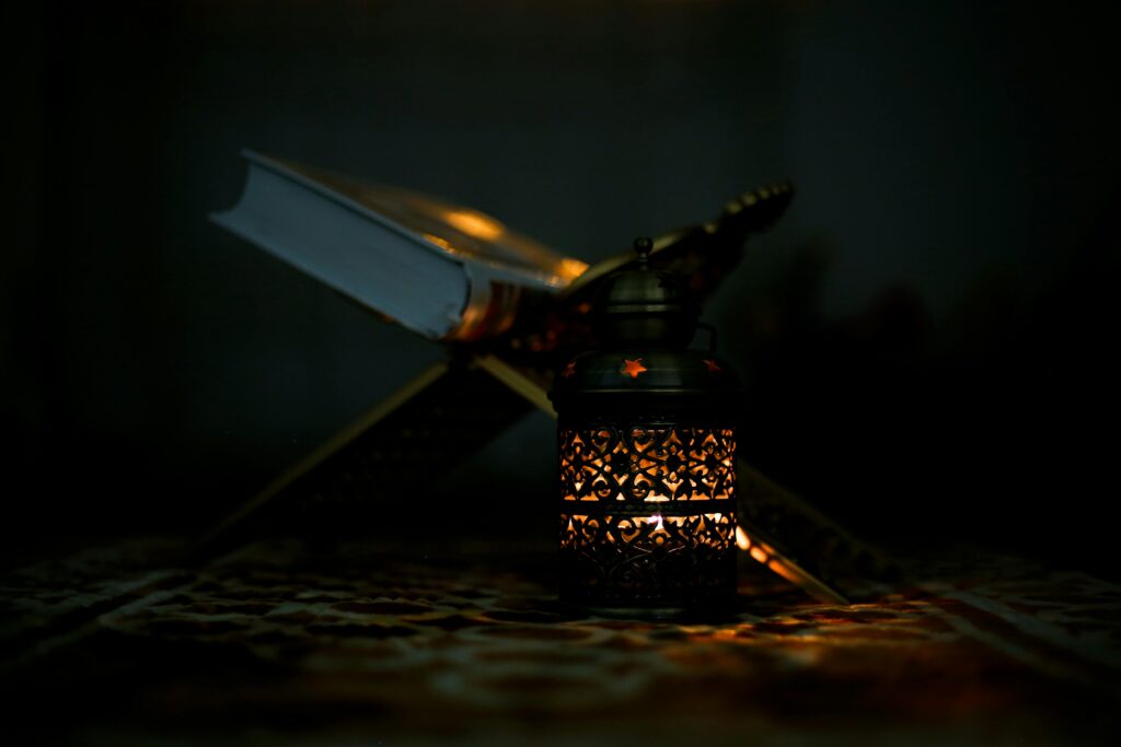 An ornate lantern illuminates an open book on a stand, creating a mystical ambiance.